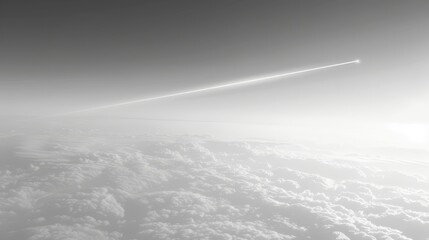 Fototapeta na wymiar A monochrome image of a plane trailing a contrail against the blue-grey sky, above clouds