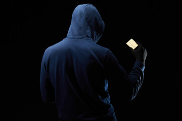 The hacker holds a credit card in his hand. Theft of personal data of credit cards. Digital...