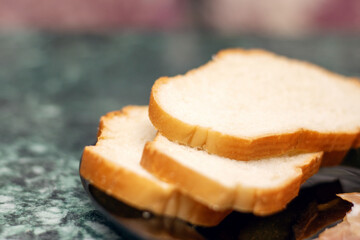 Food ingredients like slices of meat and bread served on black plate