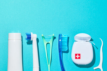 Oral hygiene supplies on a blue color background. Electric toothbrush and oral hygiene products on...
