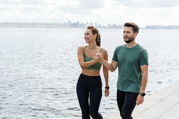 Casual riverside walk with a content couple, underlining a shared commitment to a fit lifestyle.