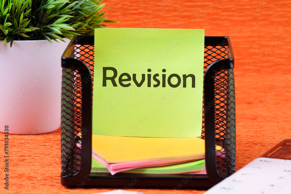 Wall mural Revision word on a sticker in a stand on an orange background