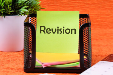 Revision word on a sticker in a stand on an orange background