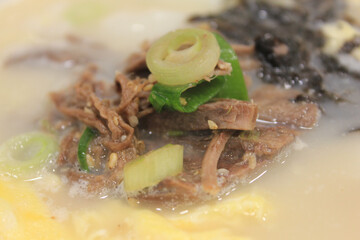 close up of sliced rice cake soup with boiled meat