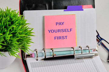 Business, finance, economic concepts. PAY YOURSELF FIRST on a sticker on the background of a blank sheet of notepad