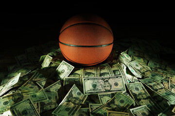 Naklejka premium Basketball on a pile of cash -- money and betting in sports concept