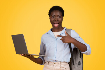 Excited african american lady zoomer shows laptop screen