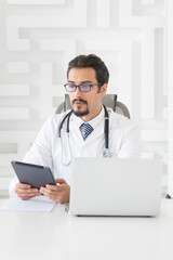 Young handsome male doctor working in the office of modern clinic	