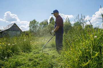 A man is working with a lawn mower on his site in the open air. Work activity.