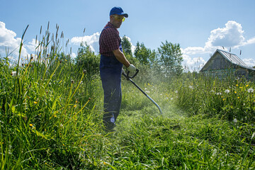 A man is working with a lawn mower on his site in the open air. Work activity.