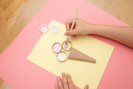 a person holding a brush over a piece of paper, a pastel, strawberry ice cream craft, summer activity