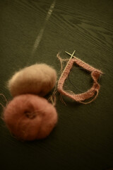 knitting project in pink color, seen on a black background