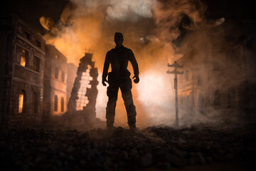Artwork decoration. A man standing on a road of burnt up city. Apocalyptic view of city downtown as...