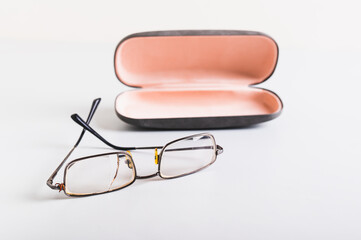 Concept of improper storage of old broken glasses on the background of a hard case on the table