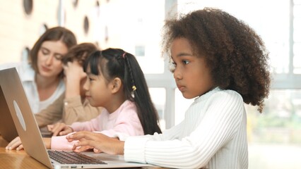 African girl play laptop with diverse friend learning prompt at STEM technology class....