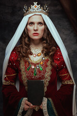 medieval queen in red dress with book, veil and crown