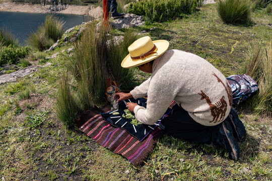 Andean man performing ritual of payment to the land in Peru, payment to the Pachamama