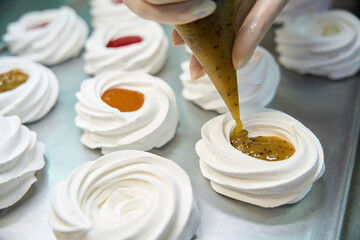 Close-up view woman baker squeezing sweet fresh kiwi curd