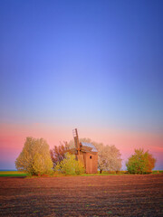 warm light after sunset on old wooden mill under evening sky with copy space