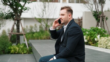 Side view of businessman sitting at park while talking to investors about marketing strategy....