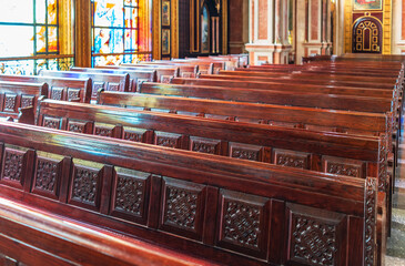 Empty wooden church benches of a Christian church. Blurry alter in the background. Selective focus....