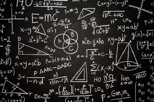 Blackboard inscribed with scientific formulas and calculations in physics, mathematics and electrical circuits. Science and education background.