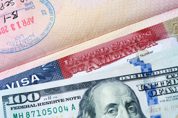 USA visa stamp in a passport and us dollar bills. Approved US visa for tourism country visit and travel. Entry and Immigration Permits. Close-up view.