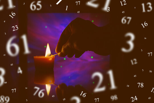 Numerology, astrology concept. Dark, candle, hand.