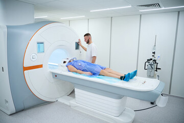 Doctor preparing man for contrast-enhanced brain magnetic resonance imaging