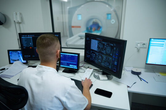 Radiographer performing brain magnetic resonance imaging on patient