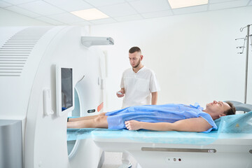 Radiographer is positioning patient for computed tomography of lower extremity