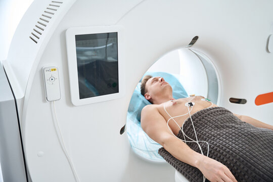Man is undergoing ECG-gated coronary computed tomography angiography