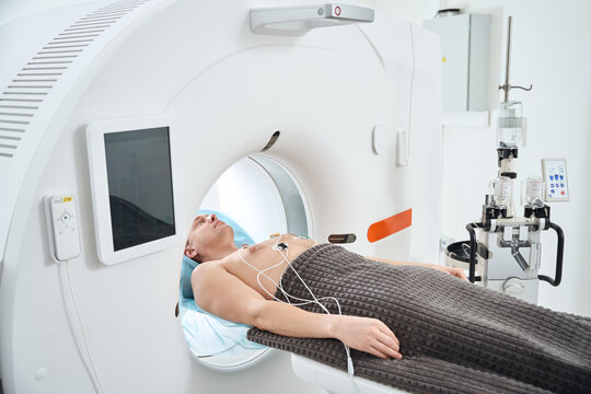 Man undergoing contrast-enhanced ECG-gated coronary CT angiography procedure