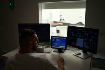 Experienced radiographer performing computed tomography on outpatient