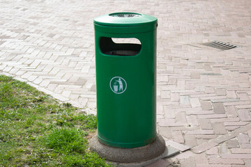 Public trash can on a city street filled with garbage