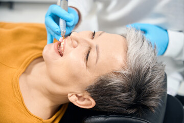 Dentist removing plaque and tartar buildup during professional hygienic cleaning
