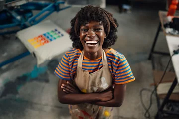 Fotobehang Portrait of interracial print shop confident female worker smiling. © Zamrznuti tonovi