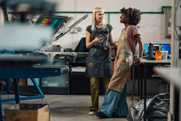Printing shop interracial female workers taking a break after hard work