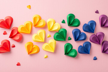 An artistic arrangement of paper hearts in a spectrum of colors representing the pride flag placed...