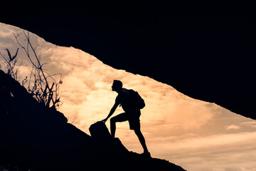 Male hiker climbing up mountain cliff, never give up, people perseverance, determination ,achieving...