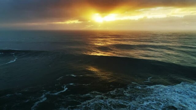 Aerial view on big waves of Atlantic ocean and dramatic sunset sky, 4k