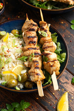 Greek grilled chicken skewers served with lemon rice and marinated green olives