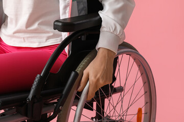 Sporty young woman in wheelchair on pink background, closeup