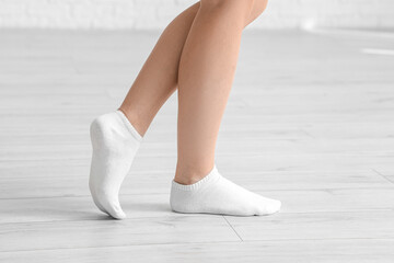 Woman in socks walking on laminate floor at home, closeup