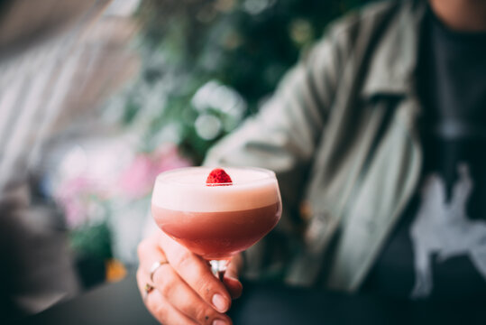 Summer vibe cocktail in martini glass, decorated with berry
