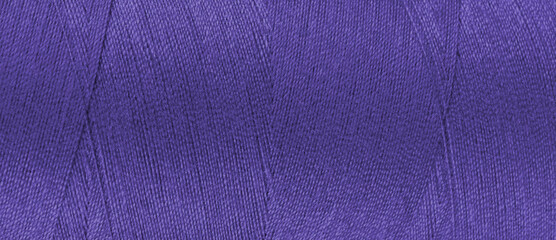 Texture of purple color threads in spool close up, macro. Wide banner, header of sewing threads...