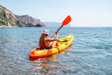 Kayak sea woman. Happy attractive woman with long hair in red swimsuit, swimming on kayak. Summer...