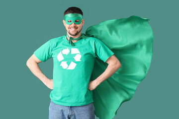 Young man dressed as eco superhero on green background. Ecology concept