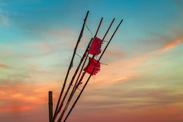 rote flaggen von einem schiff wehen im wind am meer bei schönen himmel mit untergang der sonne 