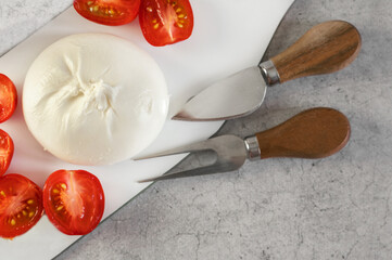 burrata with tomatoes. Caprese salad with tomatoes, burrata cheese and herbs. Soft cheese in a burrata bag - 791132371